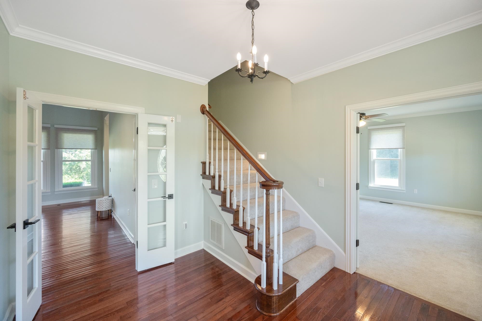 599 DT Vise Loop Parsons, TN 38363 - Photo 4 of 40 Staircase featuring crown molding, wood-type flooring, french doors, a chandelier, and a ceiling fan
