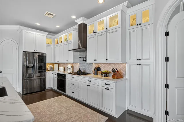 a kitchen with stainless steel appliances granite countertop a refrigerator and a sink