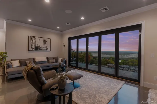 a living room with furniture and a floor to ceiling window
