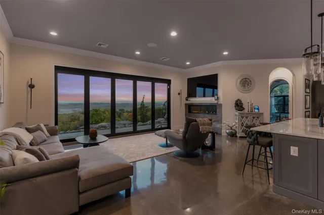 a living room with fireplace furniture and a large window