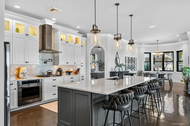 a kitchen with stainless steel appliances kitchen island granite countertop a stove a sink and a refrigerator