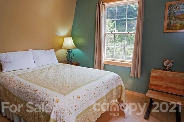 215 Meadow Branch Road Marshall, NC 28753 - Photo 11 of 32 a bedroom with a bed and wooden floor