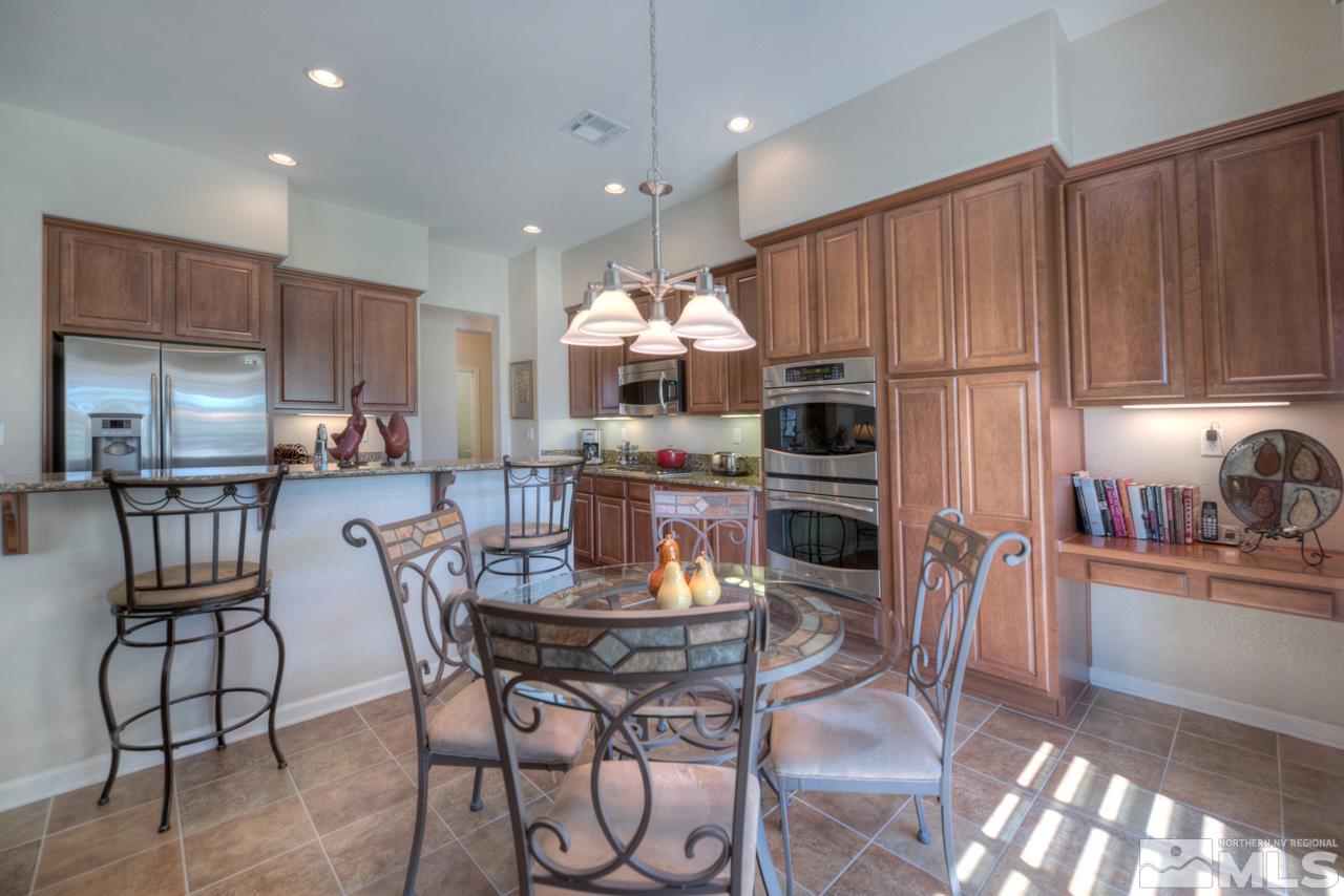 750 Sienna Station Way Reno, NV 89512 - Photo 9 of 21 a kitchen with stainless steel appliances granite countertop a stove top oven a sink dishwasher and a refrigerator with wooden floor