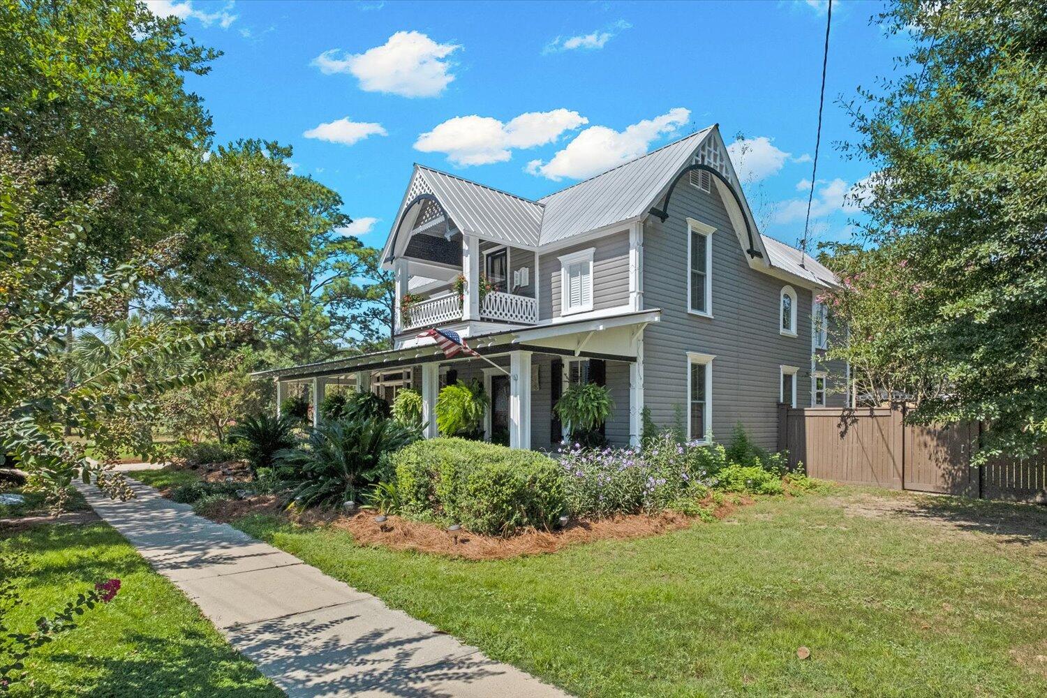 54 Plateau Avenue DeFuniak Springs, FL 32435 - Photo 5 of 114 a white house with a small yard plants and large tree