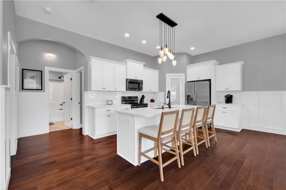 181 Amberwood Drive Anderson, SC 29621 - Photo 8 of 28 This modern kitchen features pristine white cabinetry, a spacious island, and rich hardwood flooring.