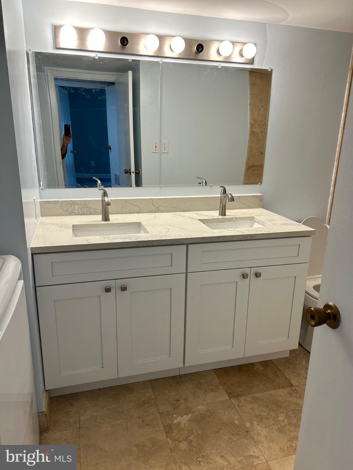 5823 Royal Ridge Drive, Unit D Springfield, VA 22152 - Photo 9 of 12 Modern dual-sink bathroom with elegant finishes.