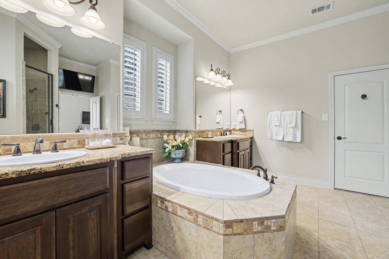 809 Prairie Dunes Drive Georgetown, TX 78628 - Photo 19 of 40 Luxurious bathing quarters with dual vanities and a deep soaking tub for ultimate relaxation.