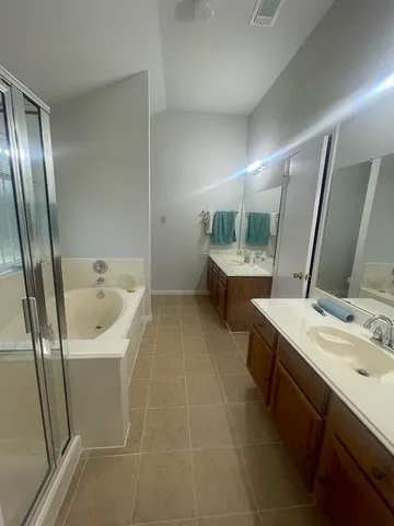 a bathroom with a bathtub sink and mirror