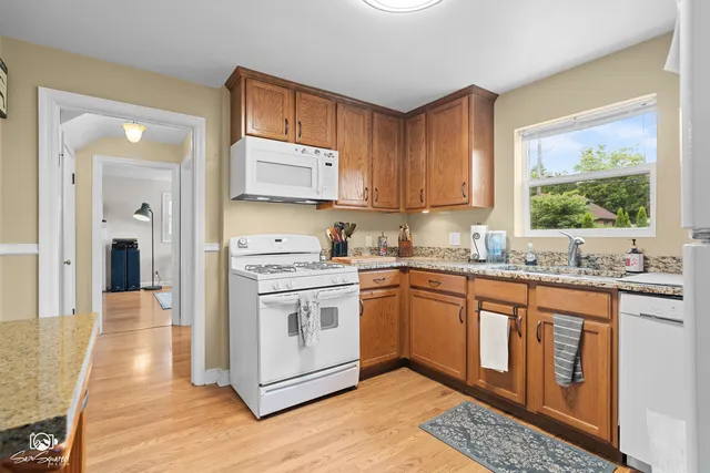 a kitchen with stainless steel appliances granite countertop a stove a sink and a microwave