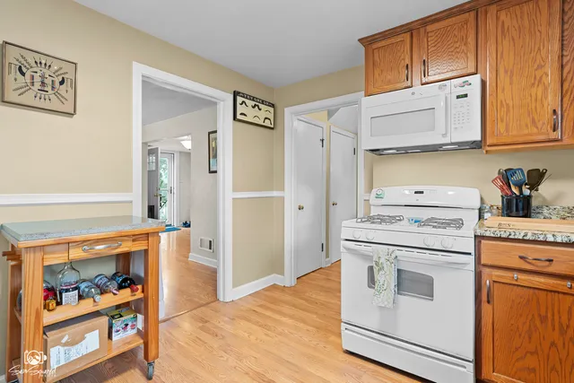 a view of a kitchen with fridge and wooden floor