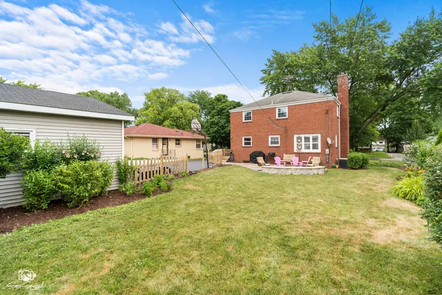 a sign board with a house in the background