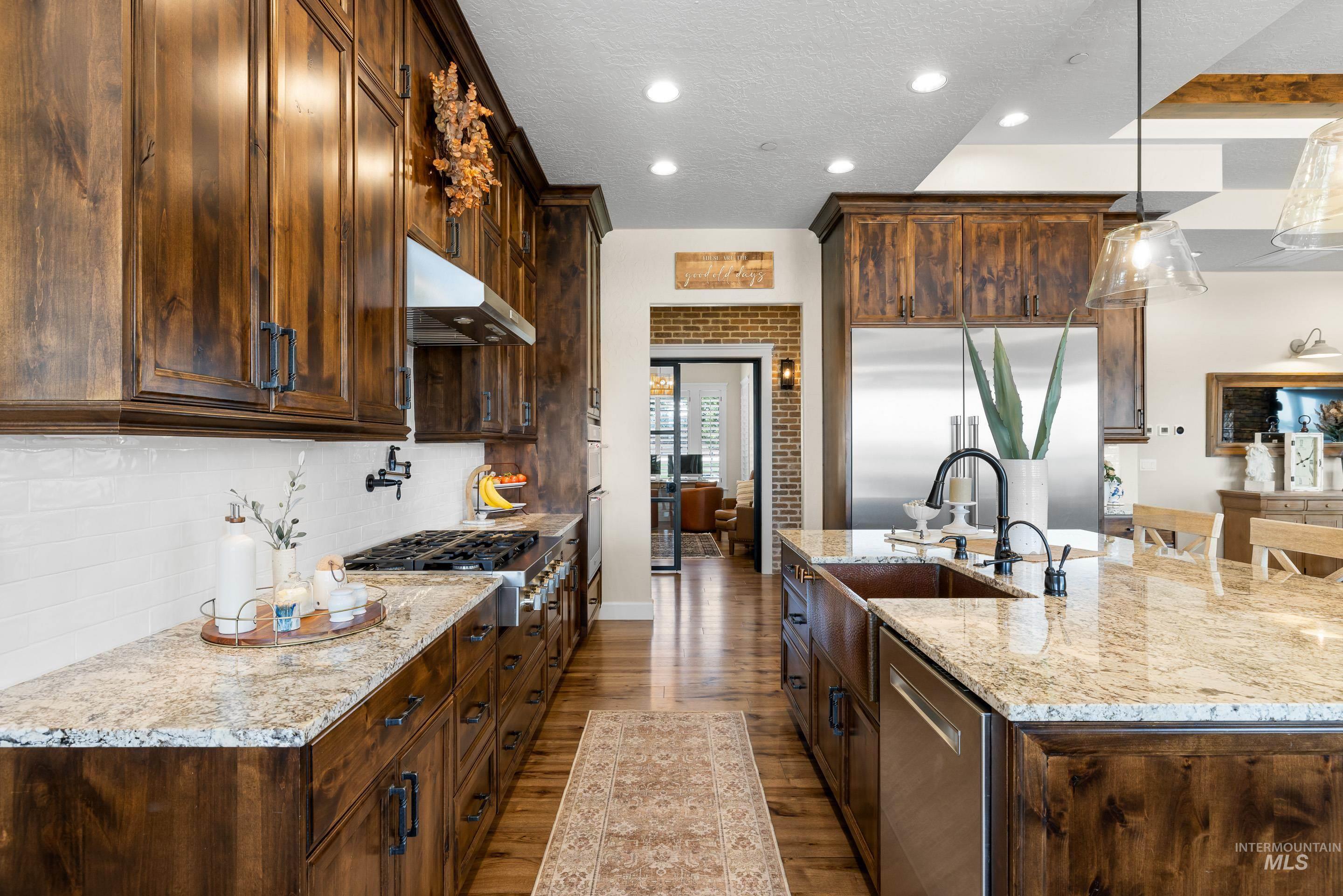 9819 Foothill Road Middleton, ID 83644 - Photo 20 of 49 Kitchen with dark wood-style floors, recessed lighting, stainless steel appliances, a textured ceiling, and light stone counters