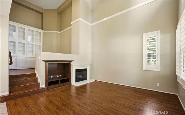 a view of an empty room with window and fire place