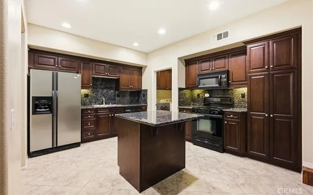 a kitchen with stainless steel appliances granite countertop a refrigerator stove and oven