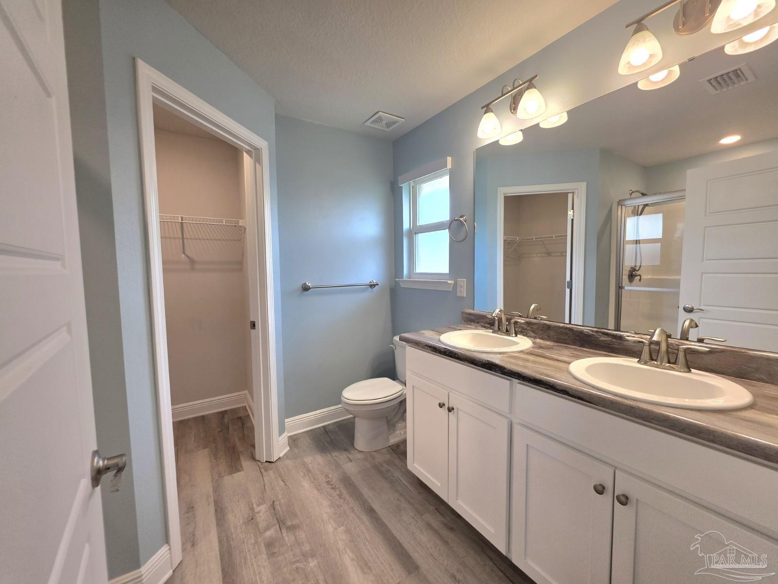 5031 Firstmate Way Pensacola, FL 32526 - Photo 12 of 27 a spacious bathroom with a double vanity sink a toilet and a mirror