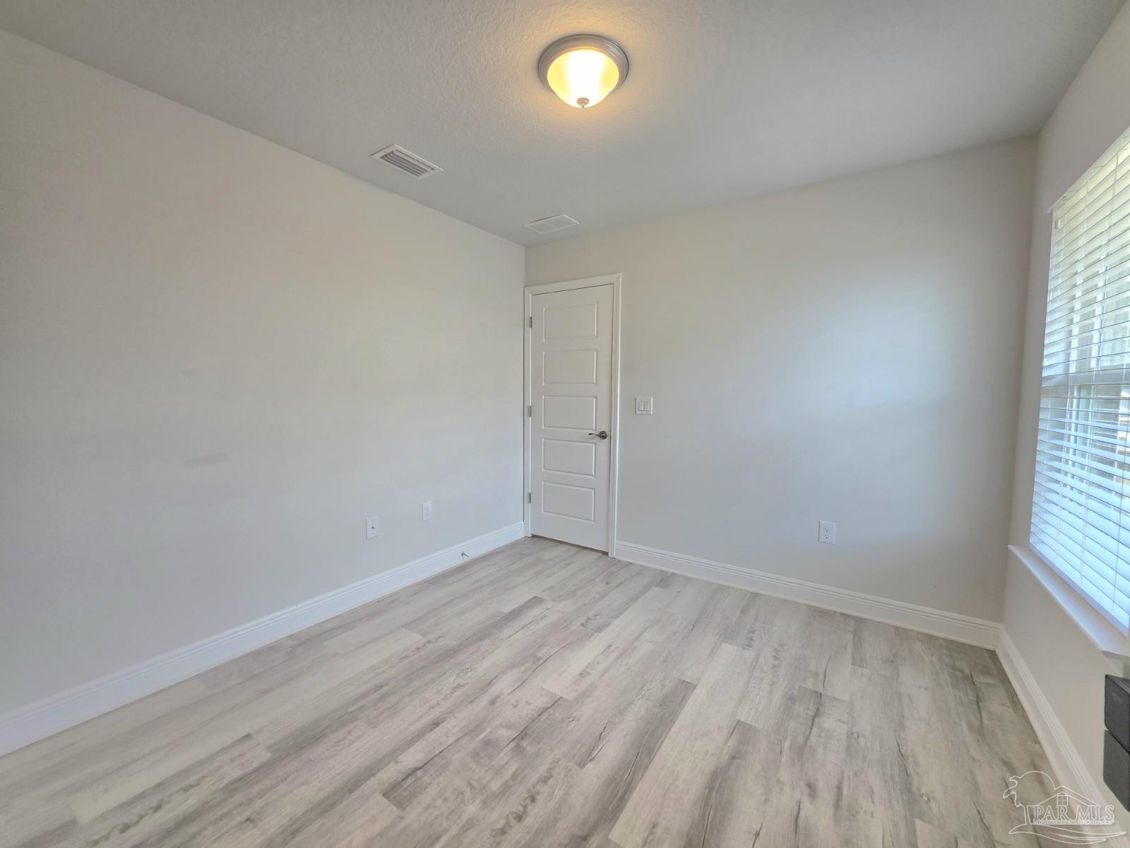 5031 Firstmate Way Pensacola, FL 32526 - Photo 17 of 27 wooden floor in an empty room with a window