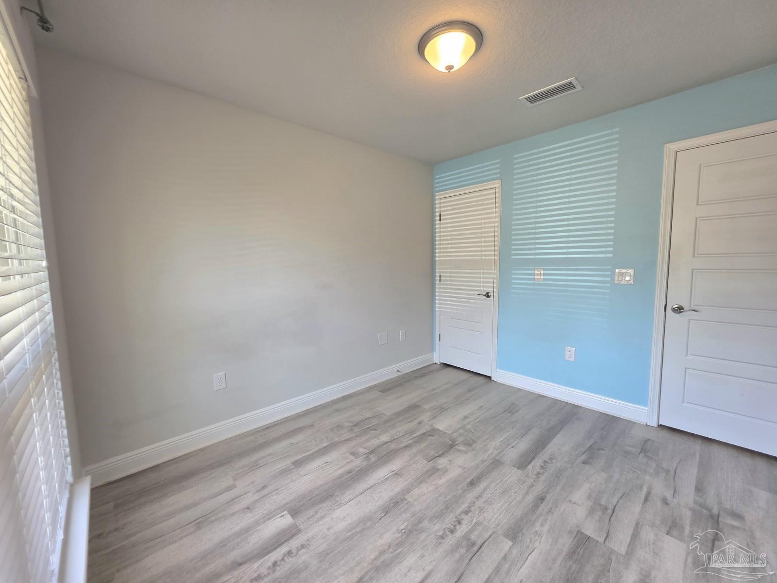 5031 Firstmate Way Pensacola, FL 32526 - Photo 21 of 27 an empty room with wooden floor and windows