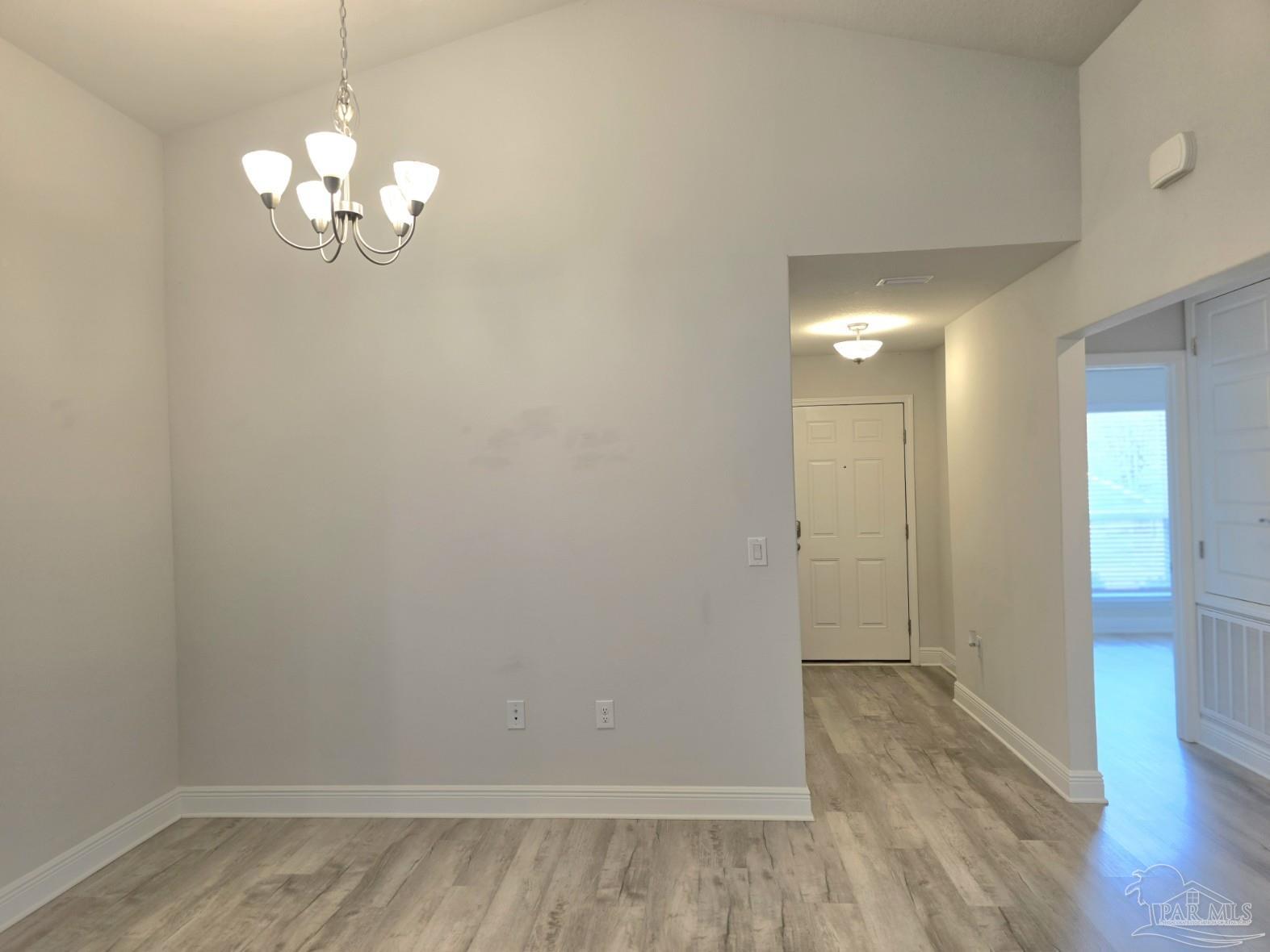 5031 Firstmate Way Pensacola, FL 32526 - Photo 4 of 27 a view of a hallway with wooden floor and a chandelier