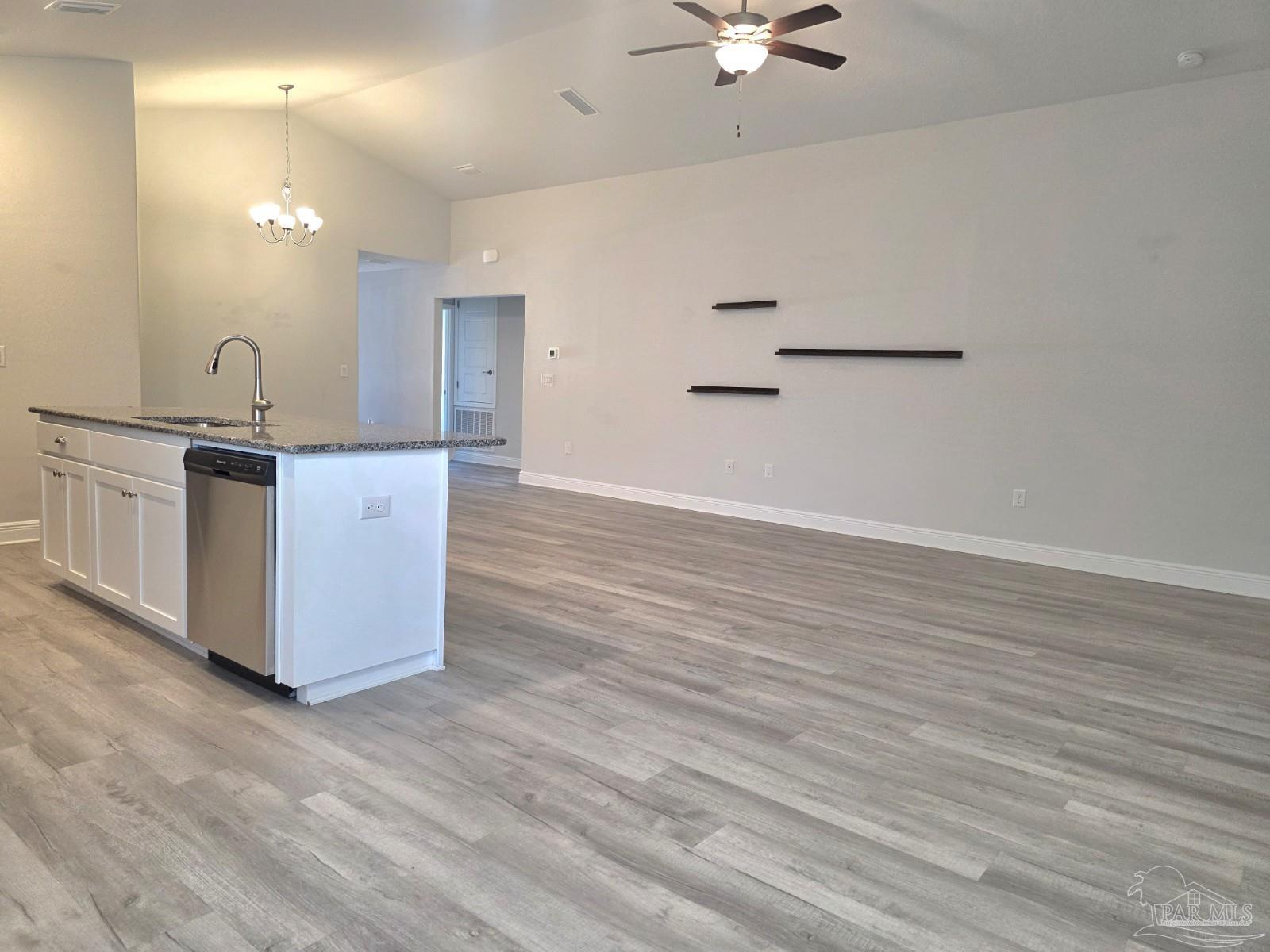 5031 Firstmate Way Pensacola, FL 32526 - Photo 8 of 27 a kitchen with granite countertop a stove and a wooden floor