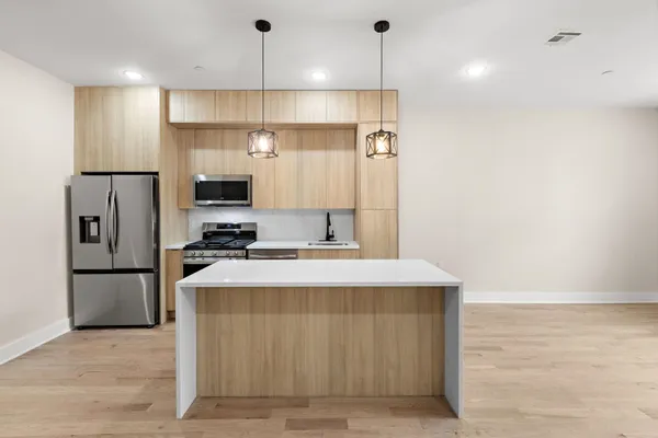 a kitchen with kitchen island a sink stainless steel appliances and refrigerator
