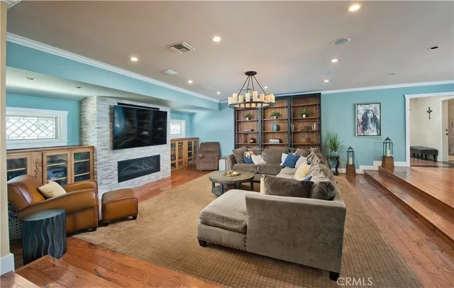 a living room with furniture a chandelier and a large window