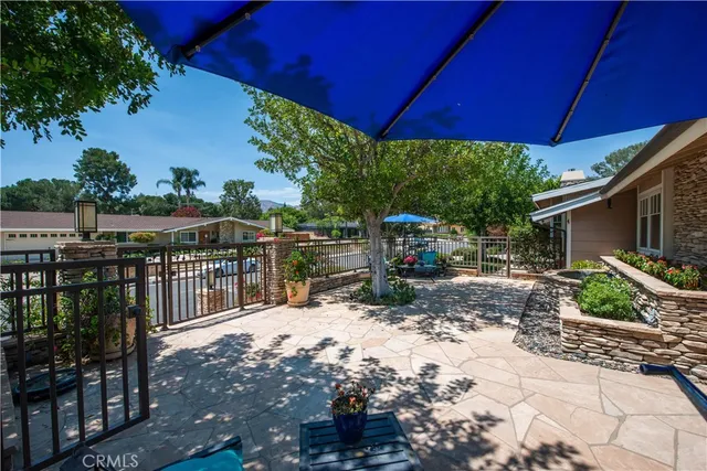 a view of a patio with table and chairs under an umbrella