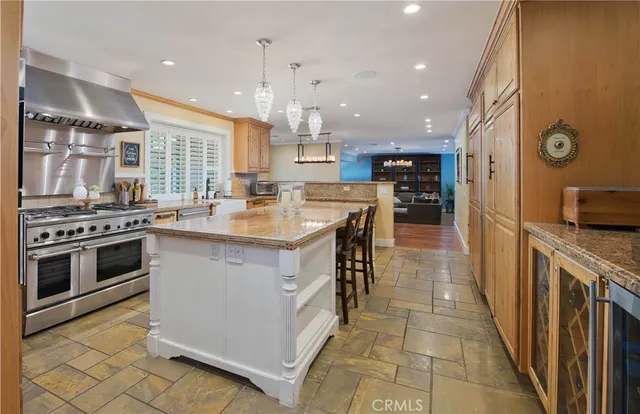a kitchen with stainless steel appliances granite countertop a stove top oven a sink a counter space and cabinets