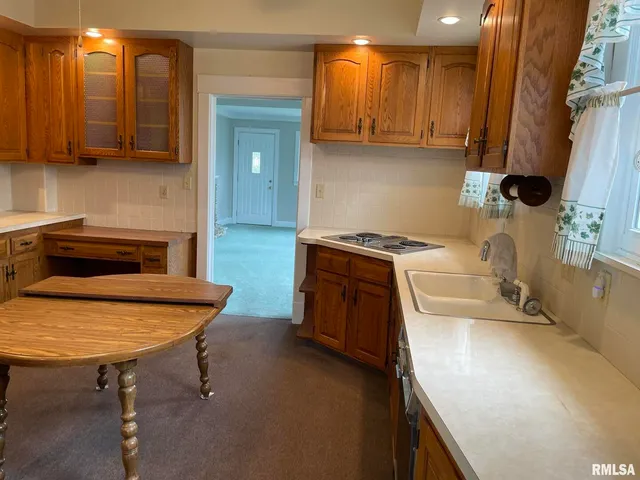 a kitchen with a sink a stove and cabinets