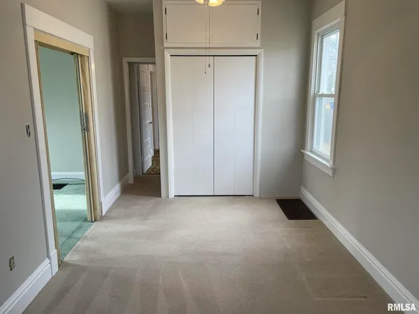 an empty room with windows and closet