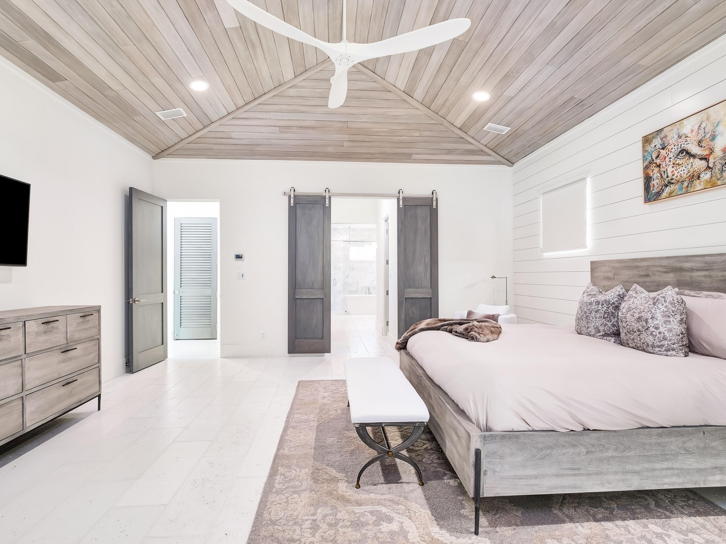 336 East Shipwreck Road Santa Rosa Beach, FL 32459 - Photo 25 of 54 a bedroom with a large bed and wooden floor