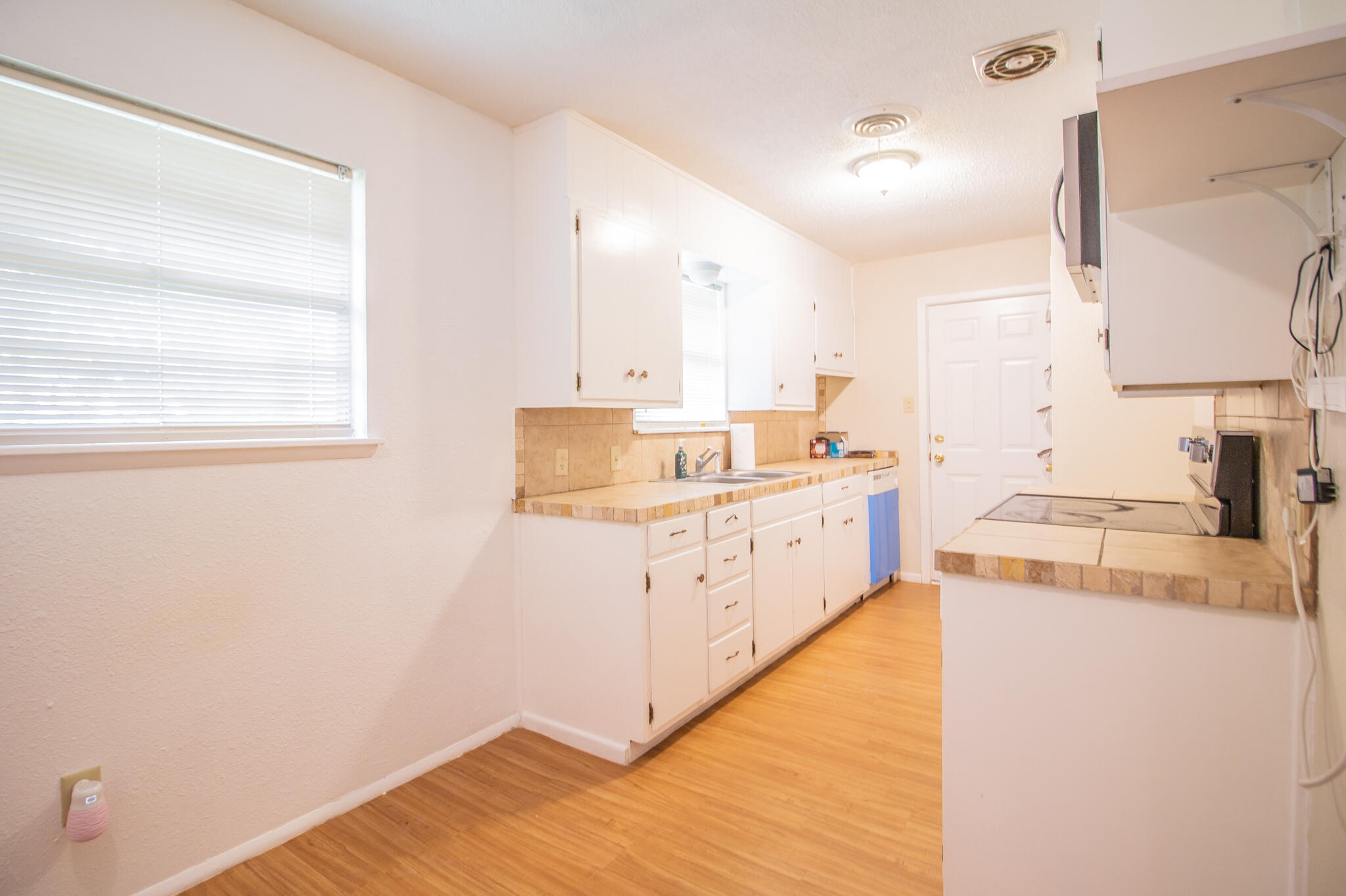 105 J B Avenue Floydada, TX 79235 - Photo 6 of 20 a kitchen with cabinets wooden floor and a sink