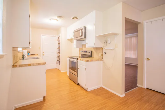 a large kitchen with a sink a stove and a refrigerator
