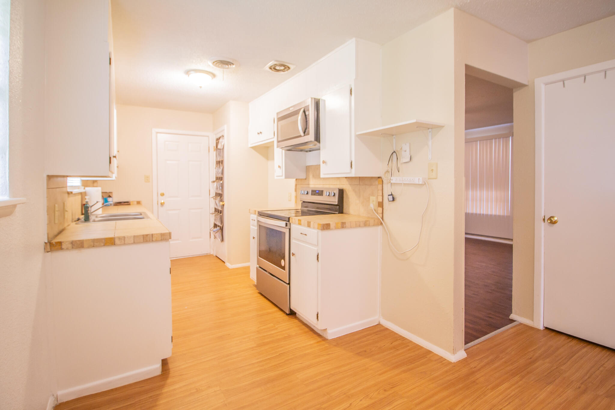 105 J B Avenue Floydada, TX 79235 - Photo 7 of 20 a kitchen with cabinets and wooden floor