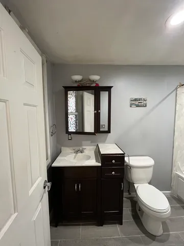 a bathroom with a toilet sink and mirror