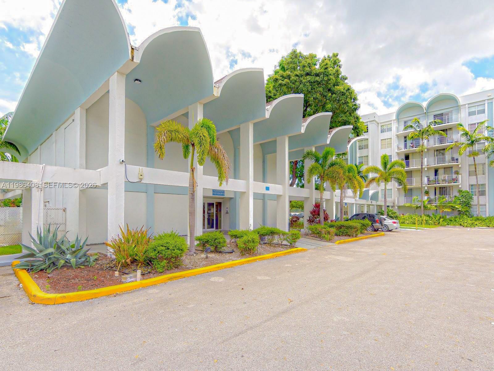 484 Northwest 165th St Road, Unit A412 Miami, FL 33169 - Photo 5 of 22 a view of multiple house with a yard and potted plants