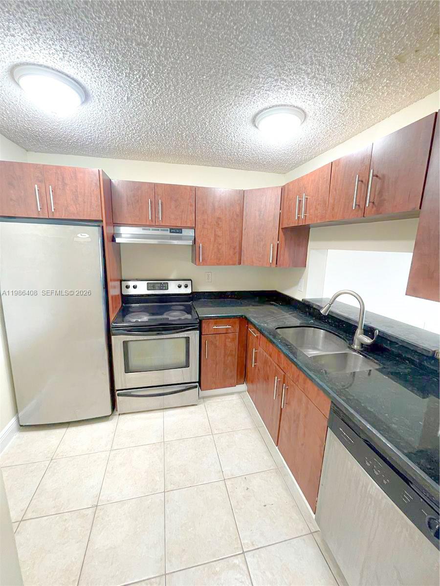 484 Northwest 165th St Road, Unit A412 Miami, FL 33169 - Photo 7 of 22 a kitchen with stainless steel appliances granite countertop a sink stove and cabinets