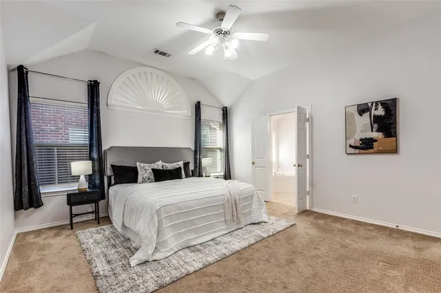 a bedroom with a large bed and a chandelier