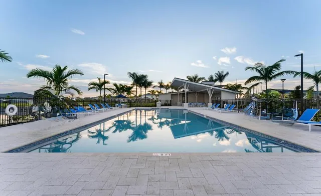 a view of a swimming pool with a patio and plants