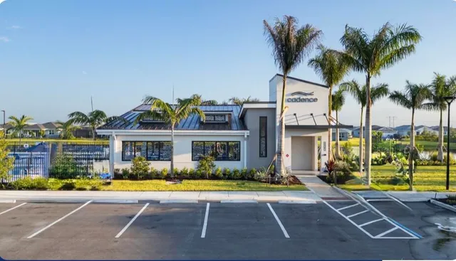 a front view of a building with glass windows and palm tree