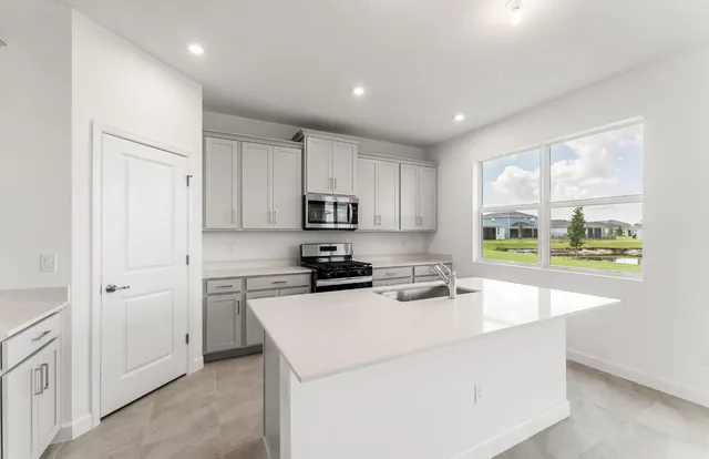 a kitchen that has a sink a stove and cabinets
