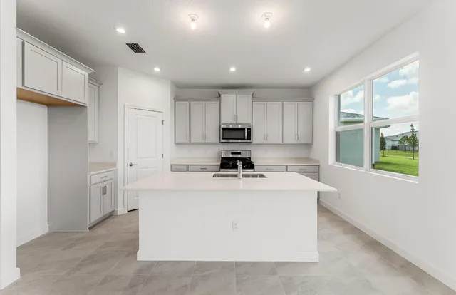 a kitchen with a stove a refrigerator and a sink