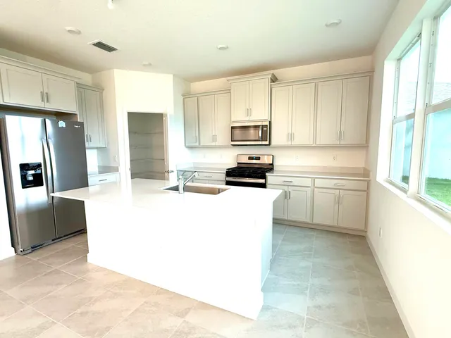 a kitchen with stainless steel appliances a refrigerator sink and cabinets