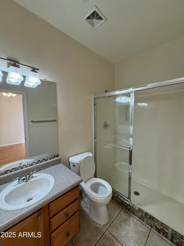 an empty room with wooden floor chandelier fan and entryway