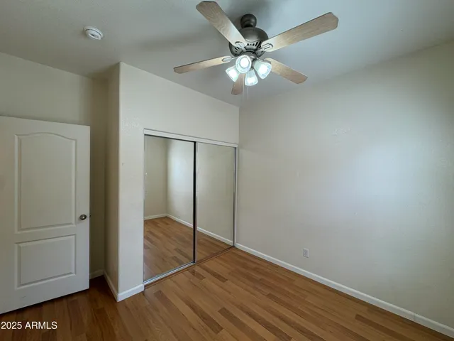 an empty room with windows and fan