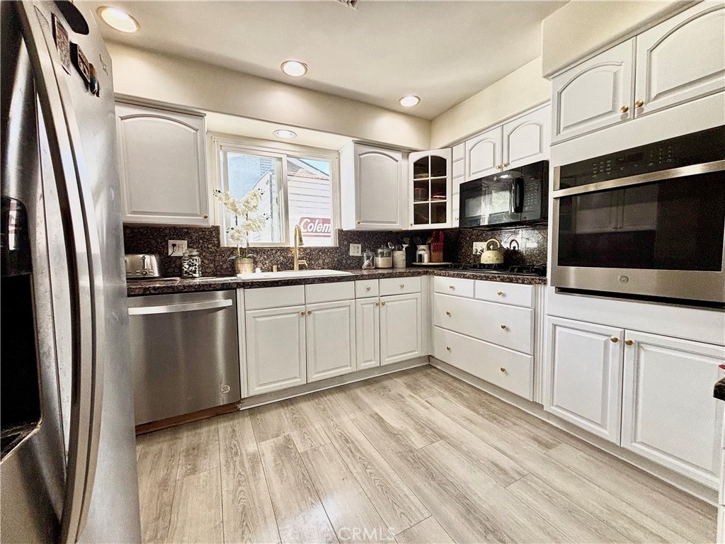 5604 Tower Road Riverside, CA 92506 - Photo 22 of 70 a kitchen with white cabinets stainless steel appliances and sink
