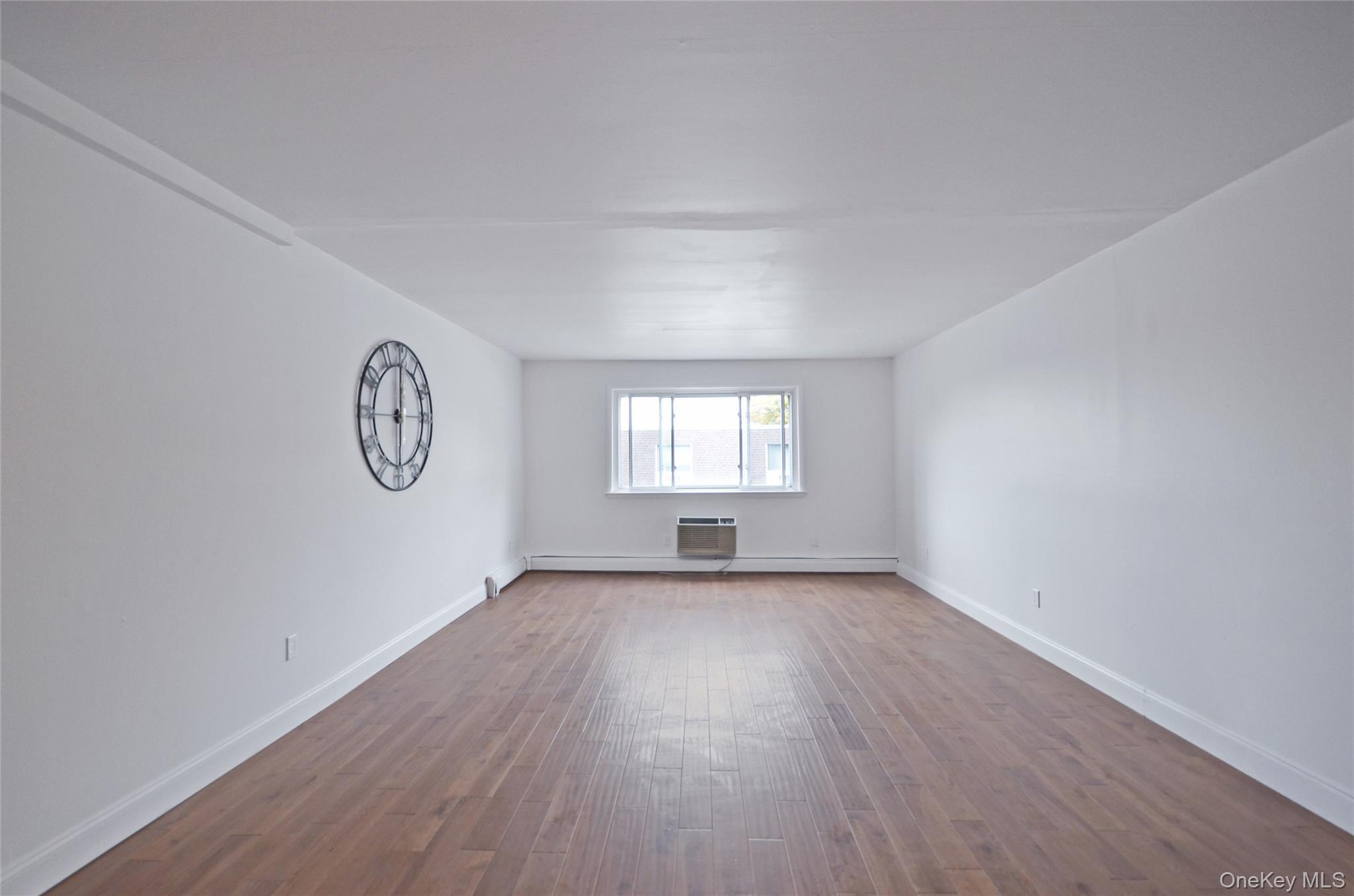 437 Palisade Avenue, Unit F1 Yonkers, NY 10703 - Photo 2 of 12 an empty room with wooden floor and windows