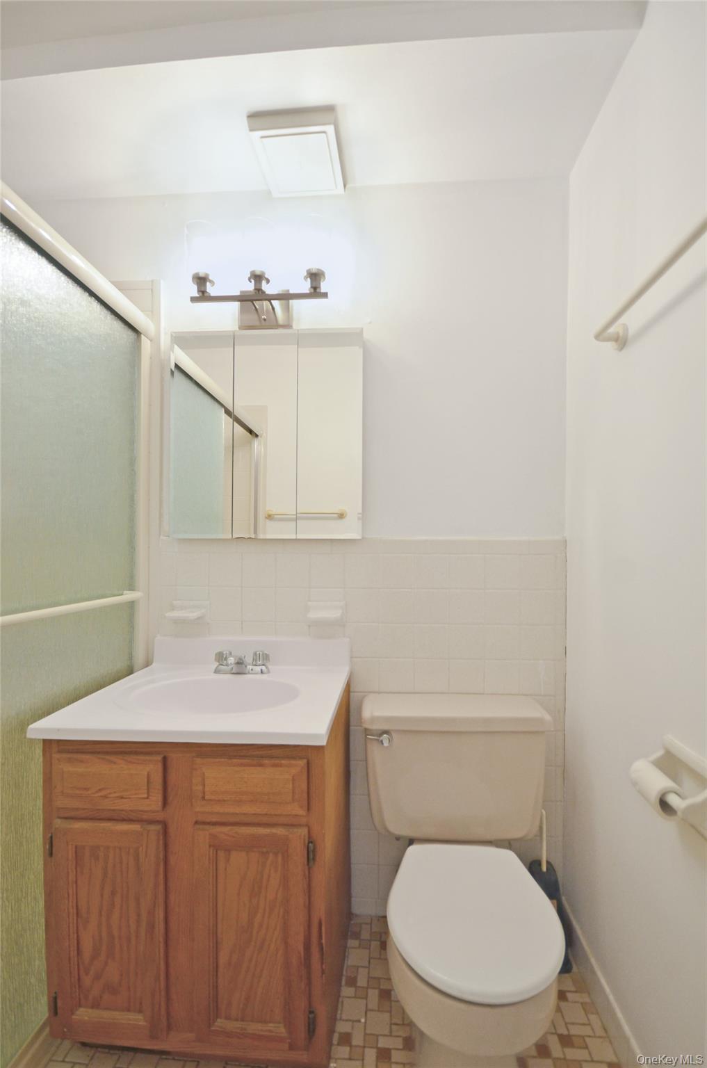 437 Palisade Avenue, Unit F1 Yonkers, NY 10703 - Photo 7 of 12 a bathroom with a toilet sink vanity and mirror