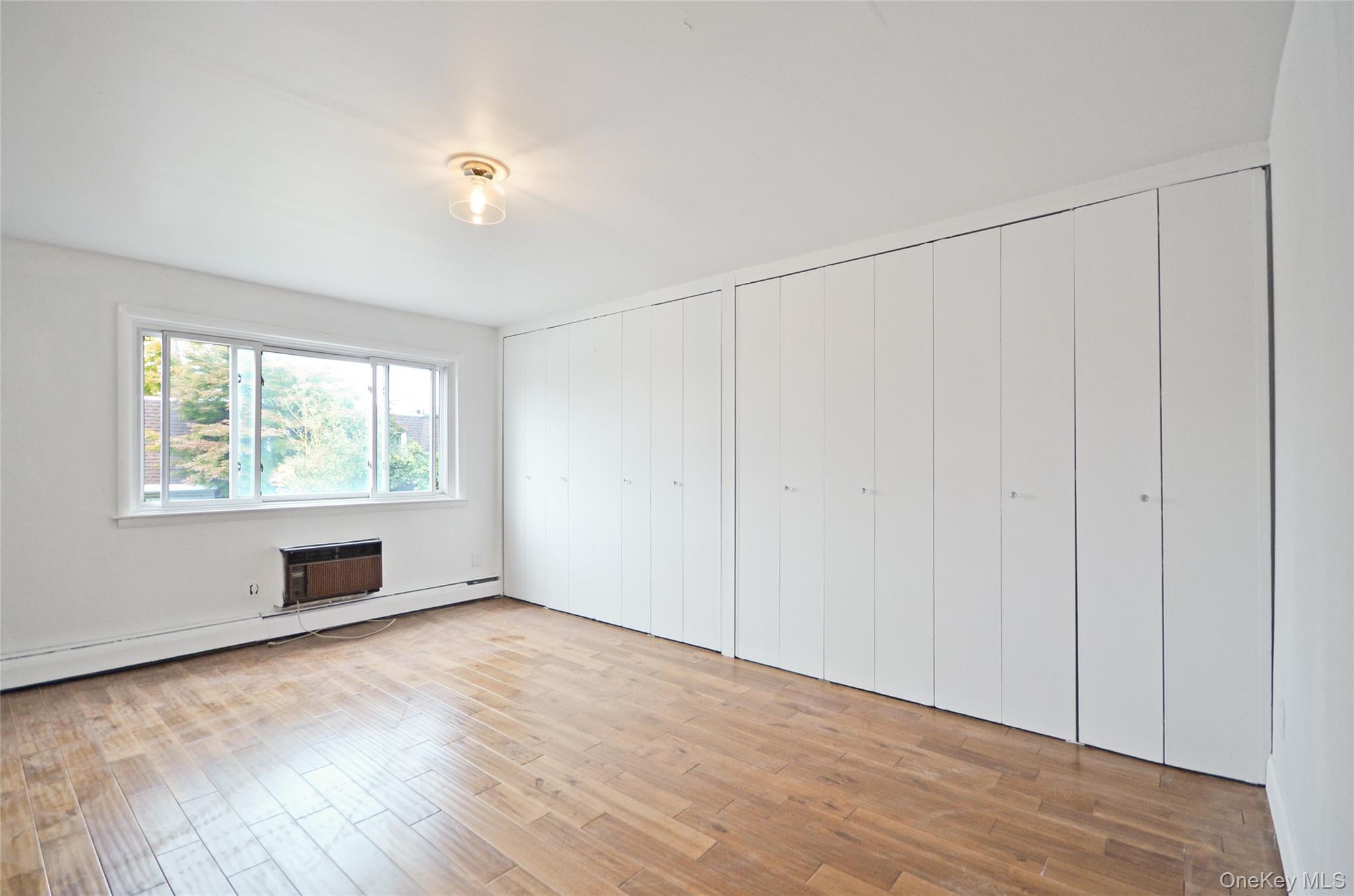 437 Palisade Avenue, Unit F1 Yonkers, NY 10703 - Photo 10 of 12 a view of an empty room with wooden floor and a window
