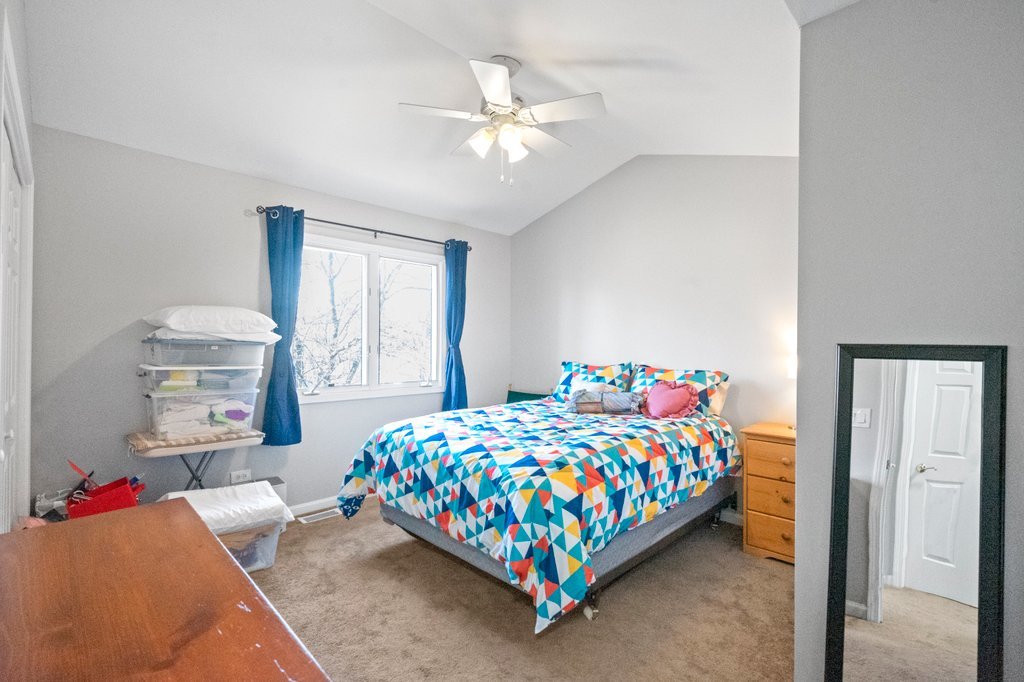 278 Charlotte Court Cary, IL 60013 - Photo 11 of 20 a bedroom with a bed and a chandelier
