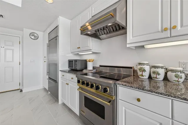 a kitchen with appliances a sink a counter top space and a center island